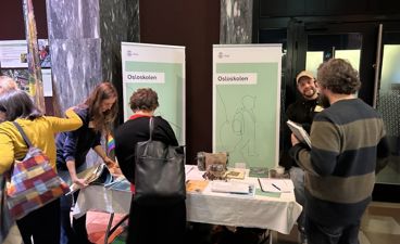 en gruppe mennesker som står rundt et bord med papirer på