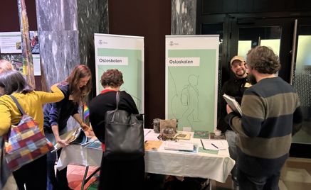 en gruppe mennesker som står rundt et bord med papirer på