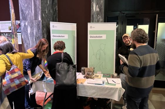 en gruppe mennesker som står rundt et bord med papirer på