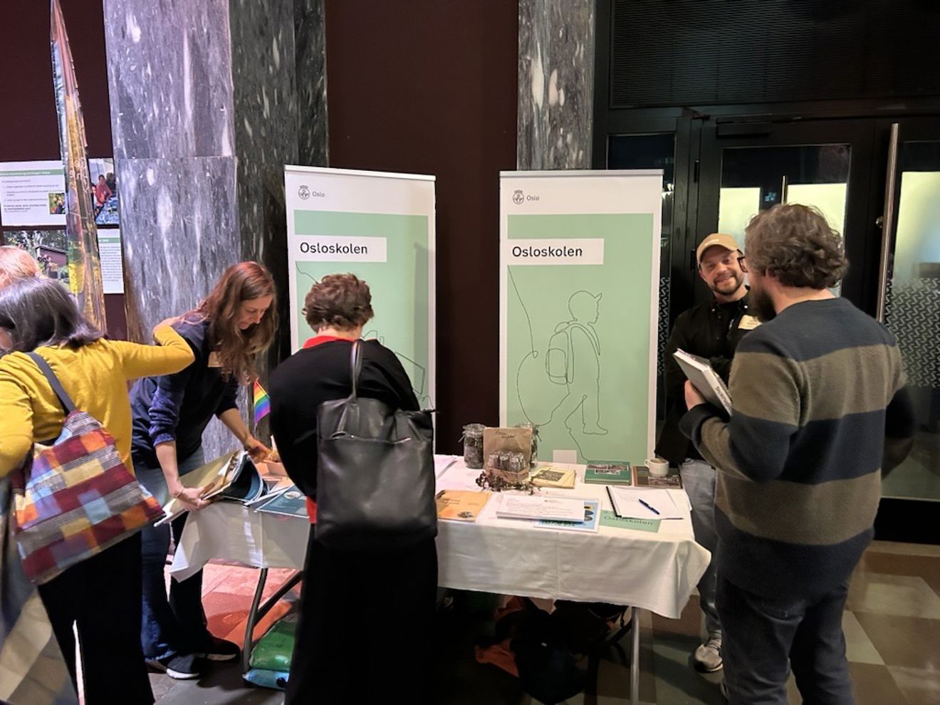 en gruppe mennesker som står rundt et bord med papirer på