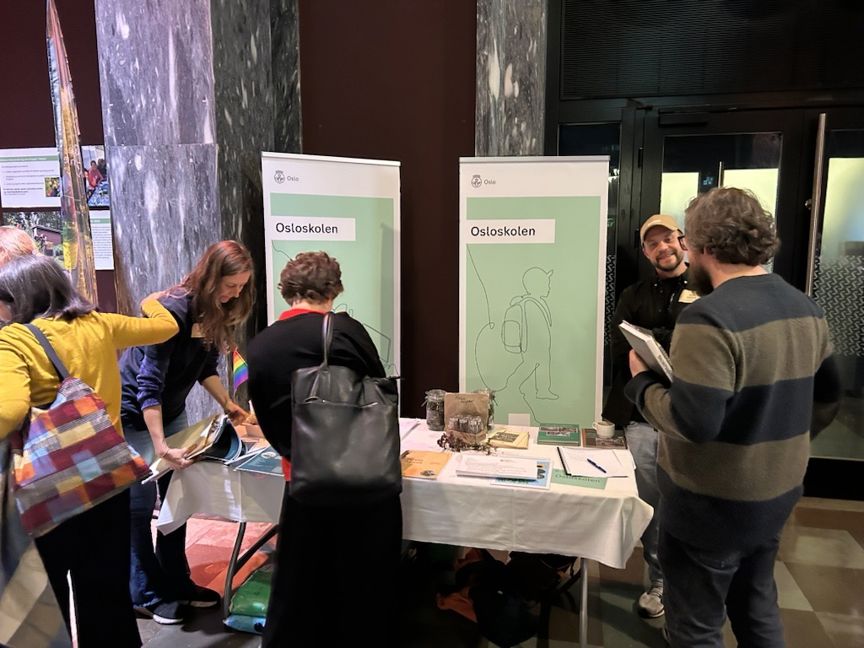 en gruppe mennesker som står rundt et bord med papirer på